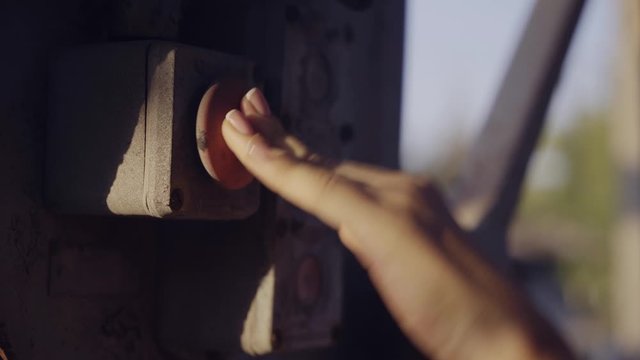 girl presses big red button on factory, factory, metal hand designs with beautiful manicure