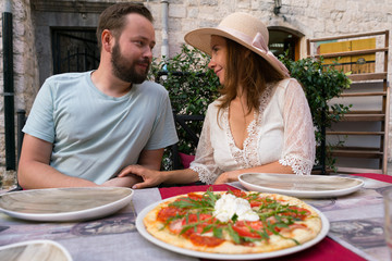 young smiling couple before eating pizza