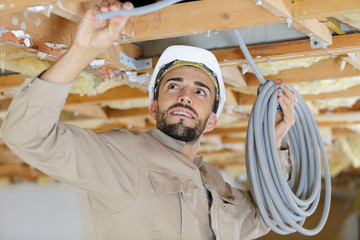 builder attaching a cables in the ceiling
