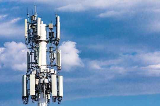 A closeup and detailed view on various GPS, cellphone, that is equipped on a telecommunication tower as seen on cloudy blue sky with copy space