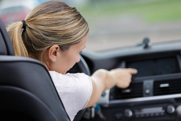 Fototapeta na wymiar woman finger pressing button in cars dashboard