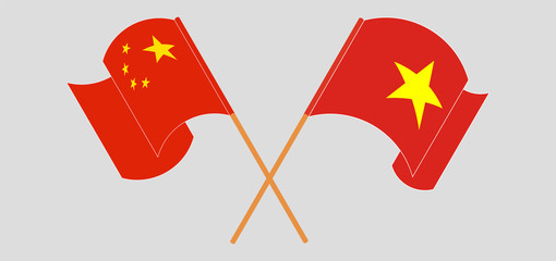 Crossed and waving flags of Vietnam and China