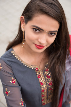 Portrait of an Indian young girl. Girl in traditional Indian clothing, salwar kameez. Girl traditional Indian decorations, bindi, chudiyan, jumka
