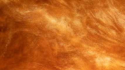 abstract golden background, paint particles shining in water, clouds of gold