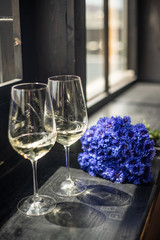 Wine glasses with a bouquet on the windowsill