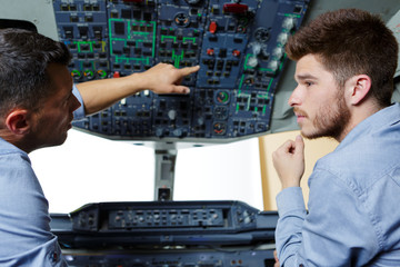 two flight engineers talking in cockpit
