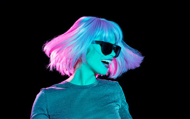 nightlife, fashion and people concept - happy young woman wearing pink wig and black sunglasses in...