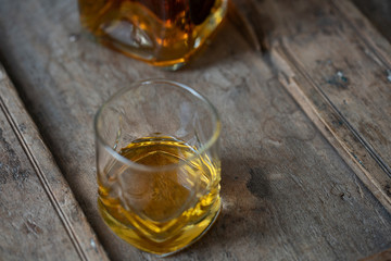 Whisky glass from above on shabby used wooden table