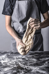Robienie ciasta bochenka chleba mąką osoba w fartuchu piekarz