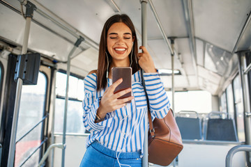 Woman Listening Music On Phone Riding In Bus. Portrait Of Stylish Smiling Girl Listening Music In...