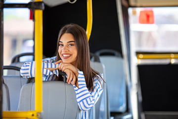 Portrait of a woman inside a bus. Beautiful young woman taking bus to work. Woman riding in a bus...