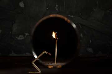 Broken match is against the mirror and the reflection shows a whole standing burning stick