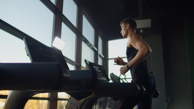 Young athletic men and women exercising and walk on treadmill in sport gym
