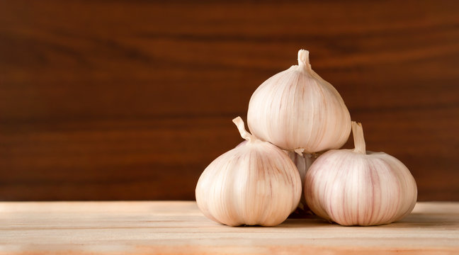 Garlic bulbs  on wooden table and dark background with copy space,food ingredient benefit for reducing blood pressure and improves blood cholesterol levels,selective focus