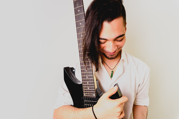 Guitarist posing with his electric guitar, white background.