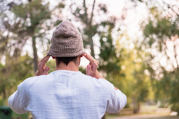 Young man puts on a hat to protect his head from the cold, he is on his back.