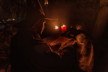 Nostradamus writing his prophesies, fantasy concept. illuminated by candles, long exposure, motion...