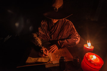 Nostradamus writing his prophesies, fantasy concept. illuminated by candles, long exposure, motion...