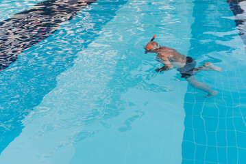 Man snorkeling in swimming pool with a mask