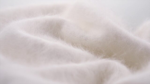 Soft wool background. Alpaca wool mohair clothes texture closeup. Natural cashmere fluffy merino wool. Woolen fabric. Rotated. 4K UHD video footage. 3840X2160