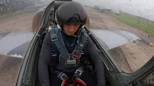 Student in flight school for the first time sits in aircraft. Man is nervous. Preparing a new pilot for flights on plane. Gray fighter plane move on runway. Inside view from cockpit close up.