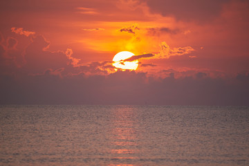 Scene of beautiful sunrise behind the cloud over the sea