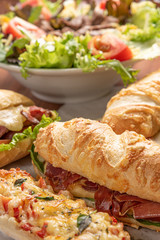Set of different sandwiches with cheese, salad of letucce and tomato on wooden background