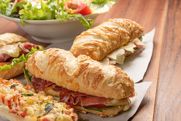 Set of different sandwiches with cheese, salad of letucce and tomato on wooden background