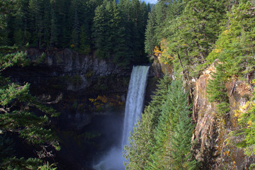 Large waterfall droping into a remote canyon with early fall colors