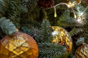 Christmas decorations. Composition of Xmas toys, cones and branches of spruce. Glowing garland. Close-up.