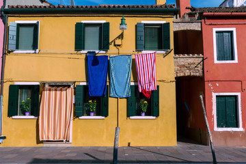 Fototapeta na wymiar colorful clothes hanging on the wall in Burano Italy