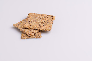 Diet flax seed whole grain crackers isolated on white background, soft light, copy space