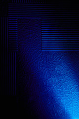 A diagonal ray of light illuminates a blue background with a pattern