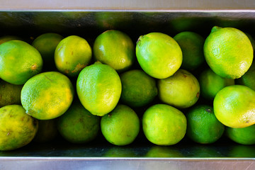 Crate of green limes at a farmers market