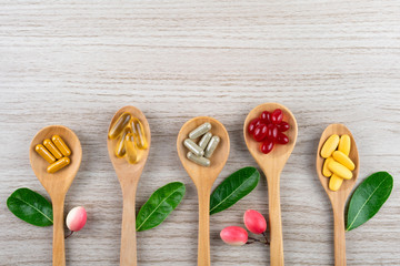 Herbal capsule from herbs nature for good health, vitamin, mineral supplement pills on wooden medical background with copy space, medicine and drug concept