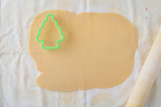 Rolled out cookie dough on pastry cloth, Christmas tree cookie cutter, cloth covered rolling pin