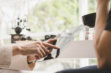 Obraz premium Business hands touch on tablet for talking about work and brainstorm to forward plan business model in coffee bar