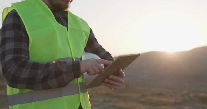 Businessman Engineer worker builder architect or engineer using tablet in industrial construction. Close-up of male man hands touching digital tablet computer.