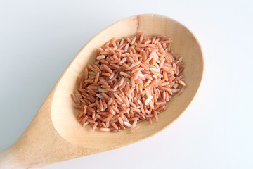 red rice in wooden spoon