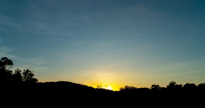 timelapse of sun goes down behind mountain silhouette