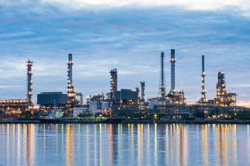 Oil and gas refinery plant area near the river at twilight, sunset time