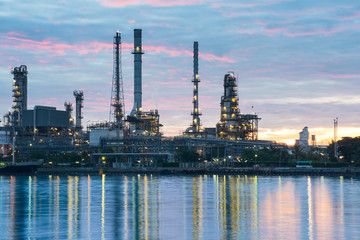 Oil and gas refinery plant area near the river at twilight, sunset time