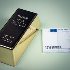 Euro cash and gold bar on a green background. Banknotes. Money. Bill. Ingot. Bullion.