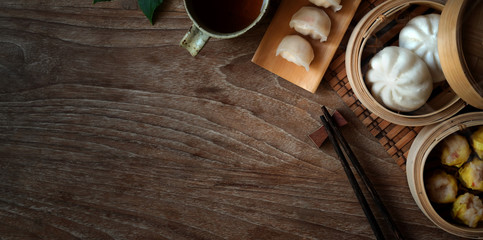 Obraz na płótnie Canvas Top view of Chinese steamed dumpling and steamed pork bun in a bamboo steamer