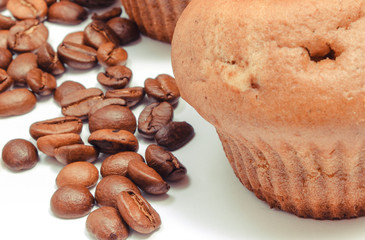 Fresh baked homemade muffins and coffee grains on white background. Delicious dessert