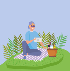 man with tablet on blanket basket wine food picnic