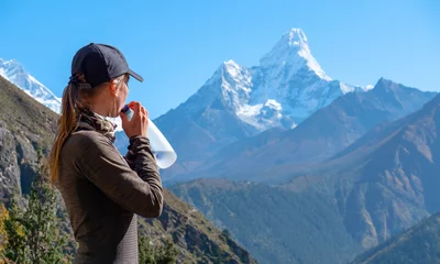 Photo sur Plexiglas Ama Dablam Active hiker hiking, enjoying the view, drink water and looking at Himalaya mountains landscape. Travel sport lifestyle concept