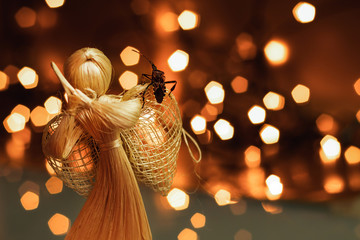 Western conifer seed bug sitting on a straw Christmas angel on a blurred background with Christmas...