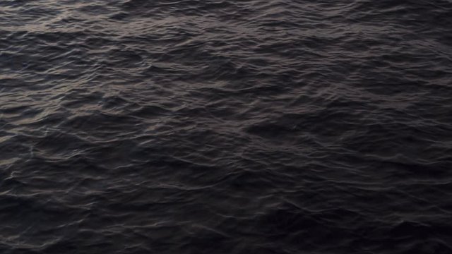 Drone Flying Over a Rippling Dark Ocean Water