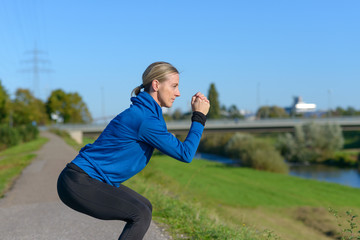 Fit woman doing crouch stretches to warm up